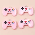 Detailed top view of four pink resin game controller charms with metallic rings - Pink