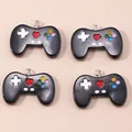Close-up of four black game controller acrylic charms with colorful buttons for DIY jewelry - Black