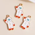 Detailed view of three enamel astronaut charms in gold alloy for DIY jewelry making - White