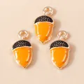 Macro detail of three enamel acorn pendants with orange shells and dotted black caps - Caramel color