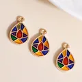 Macro view of teardrop enamel charms with colorful geometric patterns and gold alloy edges - Colorful