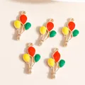 Close-up of five colorful enamel balloon charms with golden hooks for DIY jewelry - Red