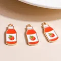 Macro shot of three strawberry milk charms with red enamel and golden loop for DIY jewelry - Orange Red