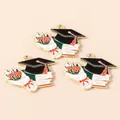 Detailed macro view of graduation alloy charms with mortarboard and rose motifs - Bouquet Style