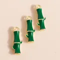 Vista detallada de colgantes de bambú en esmalte verde con bordes dorados para joyería - Verde