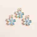 Detailed view of light blue cherry blossom enamel pendants with gold edges and crystals - Blue