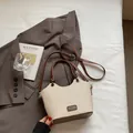 Bolso tipo cubo de paja beige con ribete de cuero marrón y asa con nudo tejido - Marrón Sin Colgante