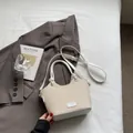 Bolso tipo cubo de paja tejida en blanco crema con correas de cuero y detalle logo - Blanco Arroz (Sin Colgante)