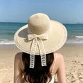 Beige wide brim straw sun hat featuring a large white lace bow for beach vacation - D-0023 Beige Pearl Lace Ribbon / M (56-58cm)