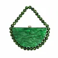 Detailed close-up of emerald green marble acrylic evening clutch with beaded handle - Dark Green