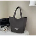 Détail du sac cabas en toile gris foncé avec lettrage blanc et bandoulière épaisse - Brun Foncé