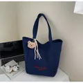 Détail du sac cabas en toile marine avec broderie rouge et breloque ours en peluche - Bleu