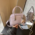 Schicke lavendelfarbene quadratische Handtasche mit Perlenanhänger und Gurt - Mit Anhänger / Lila