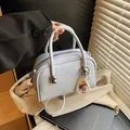 Elegante hellblaue Handtasche mit Perlenanhänger und silbernen Metallbeschlägen - Mit Anhänger / Blau