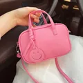 Rosa Mini-Handtasche aus Leder mit Lychee-Muster, Smiley-Anhänger und Schultergurt - 19x12x6cm / Rosa