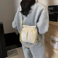 Chic cream quilted bucket bag with gold chain strap shown on model side-wear - Small / White