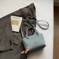 Light blue woven bucket bag with metal logo and circular handle with knot detail - Blue Without Charm