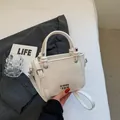 Mini white bucket bag with knotted handle, silver metal hardware, and sleek leather finish - Rice White (No Pendant)