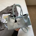 Light blue woven tote bag set with crossbody strap and white daisy charm detail - Blue