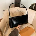 Glossy black baguette shoulder bag with slim round handle and transparent ball detail - Black