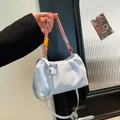Light blue ruched cloud bag featuring a unique colorful woven handle and long strap - Blue