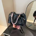 Black pleated cloud handbag with shiny finish and decorative woven rope handle - Black