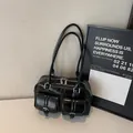 Glossy black bowling-style tote bag with dual front flap pockets and silver hardware - Black