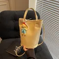 Beige minimalist bucket bag with a cute doll pendant and elegant pearl chain - Small / Yellow