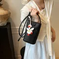 Bolso tipo cubo de cuero negro con textura de lichi y colgante de pato blanco de moda - Negro + Colgante
