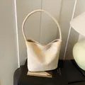 Cream bucket bag with delicate yellow floral print and elegant top handle design - Beige