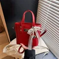 Borsa a mano in pelle PU rossa lucida con charm a fiocco di perle e ciondolo a cuore - Rosso con Fiocco Ciondolo a Cuore