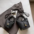 Sac seau en cuir grainé noir avec cadenas doré en deux tailles et bandoulière amovible - Grand / Noir