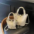 Off-white lychee leather bucket bag with gold lock and smiling face charm - Off White