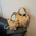 Sac seau en cuir marron de deux tailles avec fermoir doré et pendentif smiley joyeux - Grand / Kaki