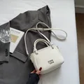 Sac seau blanc crème avec motif litchi, logo métallique et bandoulière amovible - Sans pendentif / Blanc Cassé