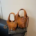 Brown vintage faux leather bucket bag with gold lock and litchi grain texture - Brown
