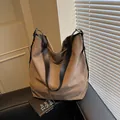 Bolso tote de lona marrón con correas de cuero negro en un sofá con estilo minimalista - Talla única / café