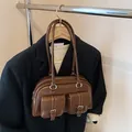 Vintage brown leather shoulder bag with dual front pockets and silver buckle accents - Brown
