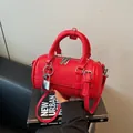 Minimalist red bowling bag in pebbled leather finish with silver padlock and key - Wine Red With Charm