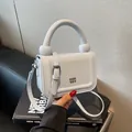 Stijlvolle witte vierkante crossbodytas met chunky handvat en metalen logo-detail - Blauw