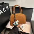 Brown leather boston bag with twin handles and a blue rocking horse charm - Yellow Brown With Charm