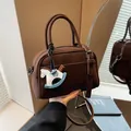 Vintage dark brown Boston-style handbag with rocking horse charm and shoulder strap - Coffee + Pendant