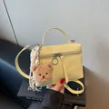 Light yellow textured mini handbag with crossbody strap and plush bear charm accent - Yellow (With Charm)