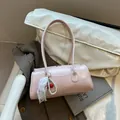 Pink cylinder shoulder bag with cherry lace pendant and faux leather finish - With Pendant / Pink