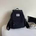 Minimalist black nylon backpack with a stylish flap and adjustable shoulder straps - Black