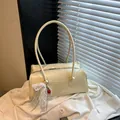 Cream vintage shoulder bag with cherry charm and pearl bow on white blazer background - With Pendant / Yellow