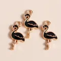 Detail of three black enamel flamingo pendants with gold alloy plating and hanging loops - Black