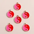 Macro shot of heart-shaped Yin Yang charms with pink and red enamel in gold finish - Rose Red Round Tai Chi
