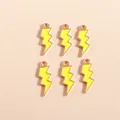 Detalle macro de seis colgantes de rayo en esmalte amarillo con bases de metal dorado DIY - Amarillo
