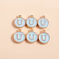 Detailed macro view of six gold-plated light blue enamel round letter U charms for DIY jewelry - Letter U